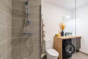 a bathroom with a shower with a toilet and a washing machine at Atlantic Selection - Le Duna - Ambiance zen avec terrasse & parking in Capbreton +41 photos