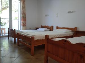 Un grupo de 4 camas en una habitación en Kapandriti Rooms, en Skala