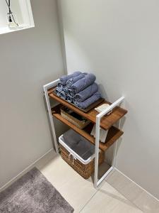 a shelf with towels and baskets in a room at Cuddle Stay in Busan