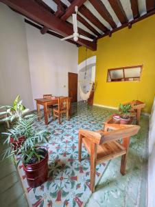 a room with tables and chairs and a yellow wall at Casa Mi María in Campeche