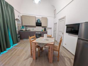 a kitchen and dining room with a table and a refrigerator at Nonna Chiara in Locorotondo