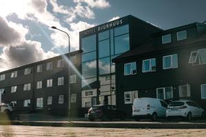 een gebouw waar auto's voor geparkeerd staan bij Hotel Djurhuus in Tórshavn
