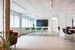 uma sala de conferências com uma mesa e cadeiras e uma televisão de ecrã plano em Hotel Djurhuus em Tórshavn