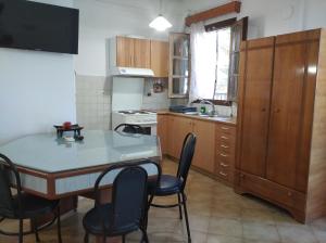 cocina con mesa, sillas y fregadero en Kapandriti Rooms, en Skala