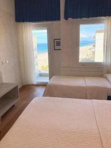 sypialnia z 2 łóżkami i widokiem na ocean w obiekcie Hotel Diplomatic w mieście Riccione