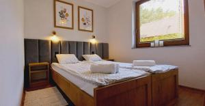 a bedroom with a large wooden bed with a window at Apartamenty na Spacerowej in Dębki