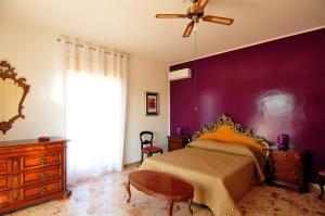 a bedroom with a bed and a purple wall at St. Lucia Suites & Apartments in Syracuse