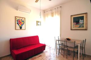シラクーサにあるSt. Lucia Suites & Apartmentsのリビングルーム(赤いソファ、テーブル付)