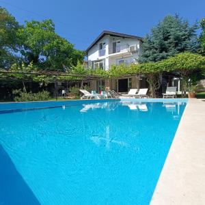 une grande piscine bleue en face d'une maison dans l'établissement Villa Regina Serafina, à Balchik