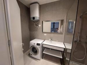 a bathroom with a washing machine and a sink at Palase Four C apartment 243-E GC in Palasë +4 photos