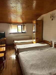 ein Schlafzimmer mit drei Betten und einem Fenster in der Unterkunft Torlacite in Chiprovtsi