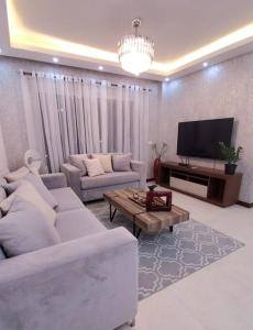 Una sala de estar con dos sofás y un televisor. en Hermoso apartamento con vista al mar y la ciudad, en La Romana