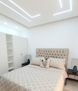 Un dormitorio con una cama grande en una habitación blanca. en Hermoso apartamento con vista al mar y la ciudad, en La Romana