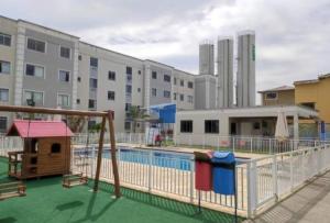 une piscine avec un toboggan et une aire de jeux dans l'établissement HollydayAppartment no Centro Rio das Ostras, à Rio das Ostras