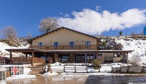 ein großes Haus mit Schnee auf dem Boden in der Unterkunft Is Cubas in Desulo