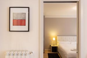 a bedroom with a white bed and a mirror at Elegante rifugio Shakespeare con parcheggio a Trieste in Trieste