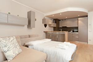a living room with two beds and a kitchen at Elegante rifugio Shakespeare con parcheggio a Trieste in Trieste
