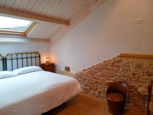 a bedroom with a bed and a stone wall at Casas rurales Villa la Roza in La Utrera