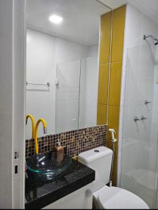 La salle de bains est pourvue d'un lavabo, de toilettes et d'une douche. dans l'établissement HollydayAppartment no Centro Rio das Ostras, à Rio das Ostras