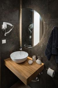 un baño con lavabo y espejo en Minoas Suite the sense of luxury, en Heraclión