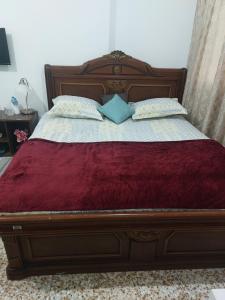 a wooden bed with two pillows on it at Furnished bedroom near Abu Dhabi Corniche in Abu Dhabi