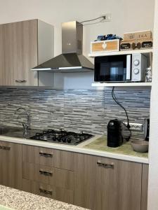 a kitchen with a stove and a microwave at Sardegna Pittulongu in Olbia