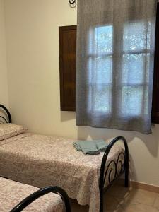 a bedroom with two beds and a window at Sardegna Pittulongu in Olbia