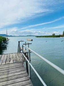 un molo su un lago con una barca in acqua di Kuckó a parton a Fonyód