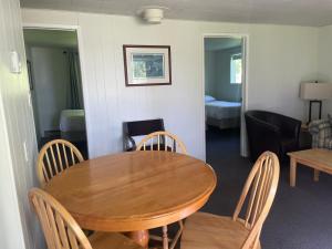 ein Esszimmer mit einem Holztisch und Stühlen in der Unterkunft Colonial Bay Motel and Cottages in Huntsville