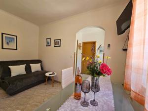 sala de estar con sofá y mesa con copas de vino en Apartmani Rita Oliva, en Novigrad Istria