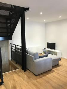 a living room with a white couch and a television at Maison en centre ville de Langeais in Langeais