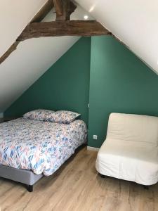 a bedroom with a bed and a chair in a attic at Maison en centre ville de Langeais in Langeais