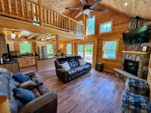 a living room with couches and a fireplace in a cabin at 31R Brand new log home on quiet side street in Bethlehem, close to Main Street! 20 min to skiing in Bethlehem