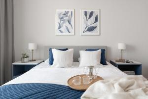 een slaapkamer met een blauw en wit bed en een dienblad bij Old Town - River Point by Welcome Apartment in Gdańsk