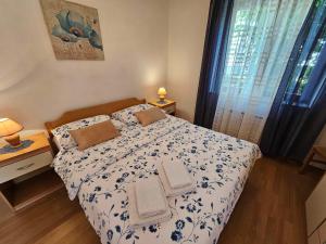 a bedroom with a bed with two towels on it at Apartmani Rita Oliva in Novigrad Istria