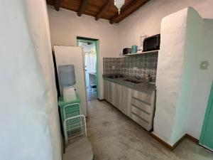 a small kitchen with a sink and a refrigerator at El Campito Cabaña de montaña in Rodeo