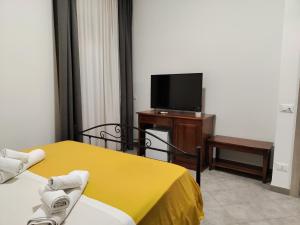 Cette chambre comprend un lit et une télévision à écran plat. dans l'établissement B&B Sanacore, à Guarrato