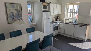 a kitchen with a white table and blue chairs at Tversted Strandpark in Bindslev