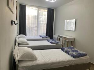 a group of four beds in a room with a window at Palase Four C apartment 190-A GC in Palasë