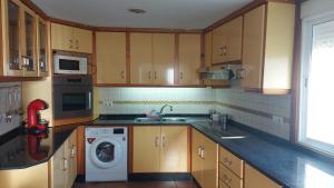 a kitchen with a sink and a washing machine at Casa cheve in Cangas de Morrazo