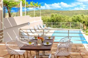 a patio with a table and chairs and a pool at Cretan Breeze Villa Heated Pool in Dhrámia