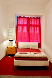 a bedroom with a red curtain and a bed with a red rug at Volkstheater Apartment. in Vienna