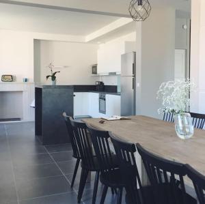 a kitchen with a wooden table and chairs in it at Maison Gabriel - Jacuzzi in Pogny