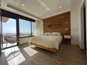a bedroom with a large bed and a large window at OASIS PRESTIGIO in Huétor Vega +11 photos