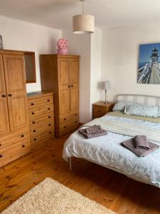 een slaapkamer met 2 bedden, houten kasten en een tapijt bij Explore Kerry and the wild Atlantic way in Lixnaw