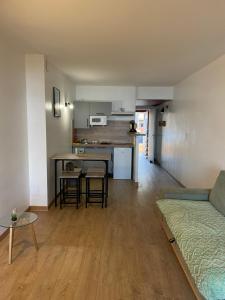 a living room and kitchen with a couch and a table at Studio accès plage in Six-Fours-les-Plages
