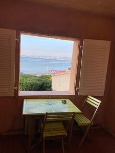 a table and two chairs in a room with a window at Studio accès plage in Six-Fours-les-Plages