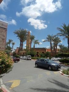 samochód zaparkowany na parkingu z palmami w obiekcie Riad les fleurs de Lys de Al qaria Assiyahia w Marakeszu