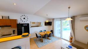 a kitchen and dining room with a table and a clock at Apartman Bebic in Klek
