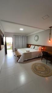 a large bedroom with a large bed and a table at Pousada Timoneiro in Vila Velha